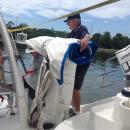 Loading the jib.: Peter Backhouse putting the jib in the dinghy, on it